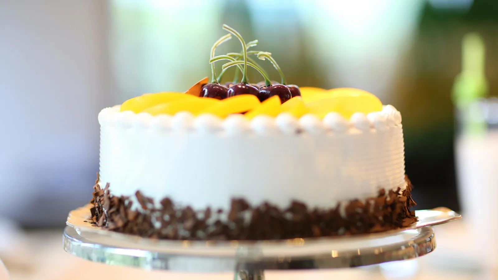Round White Frosted Cake with Peach Slices & Cherries